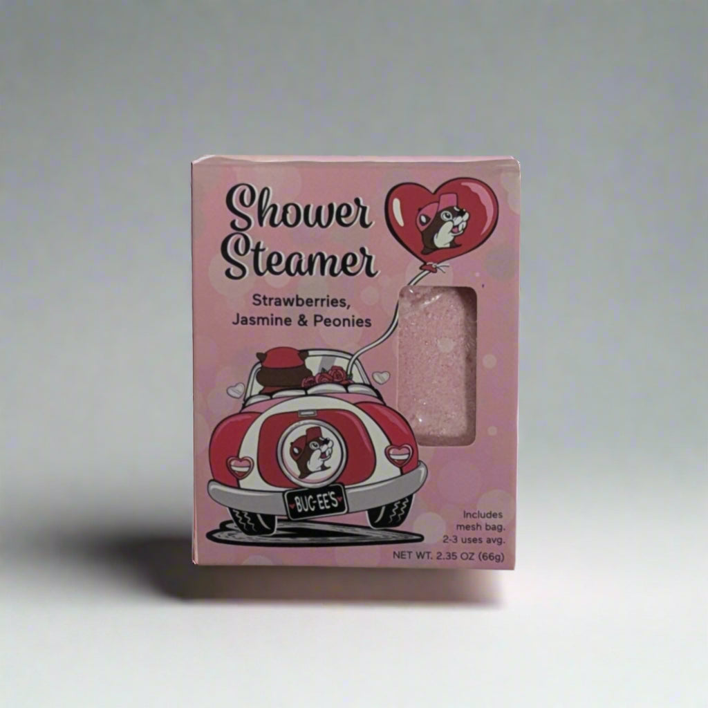 Pink Buc-ee’s Valentine Shower Steamer packaging featuring a retro car, heart design, and text highlighting the strawberries, jasmine, and peonies scent.