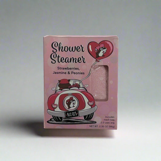 Pink Buc-ee’s Valentine Shower Steamer packaging featuring a retro car, heart design, and text highlighting the strawberries, jasmine, and peonies scent.